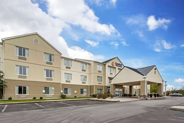 A hotel with a beige exterior, multiple windows, and a covered entrance. - Comfort Inn & Suites Corbin North (Corbin)