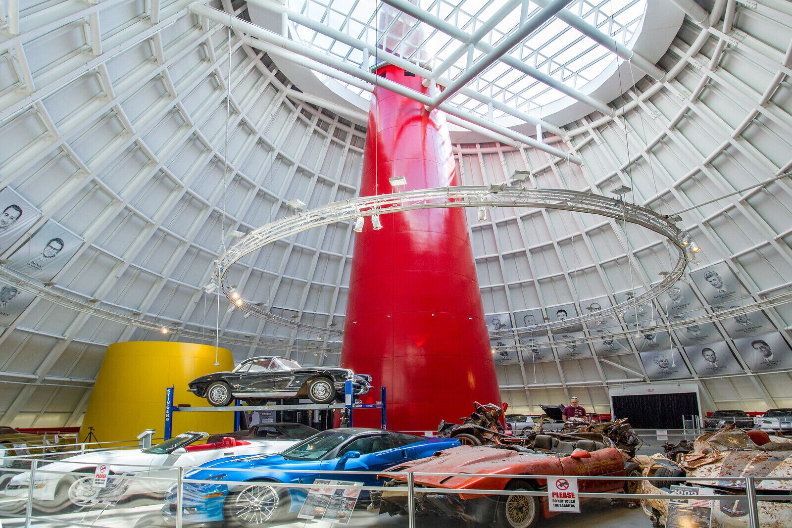 Un amplio espacio interior con techo alto y una columna roja destacada.