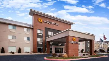 Un hôtel La Quinta doté d’une façade moderne, d’une entrée abritée et d’un parking.