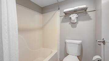 A bathroom with a bathtub, toilet, towel rack, and shower curtain.