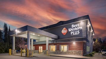 Een Best Western Plus hotel met een modern design, herkenbaar aan een opvallend bord en een overdekte parkeerplaats.