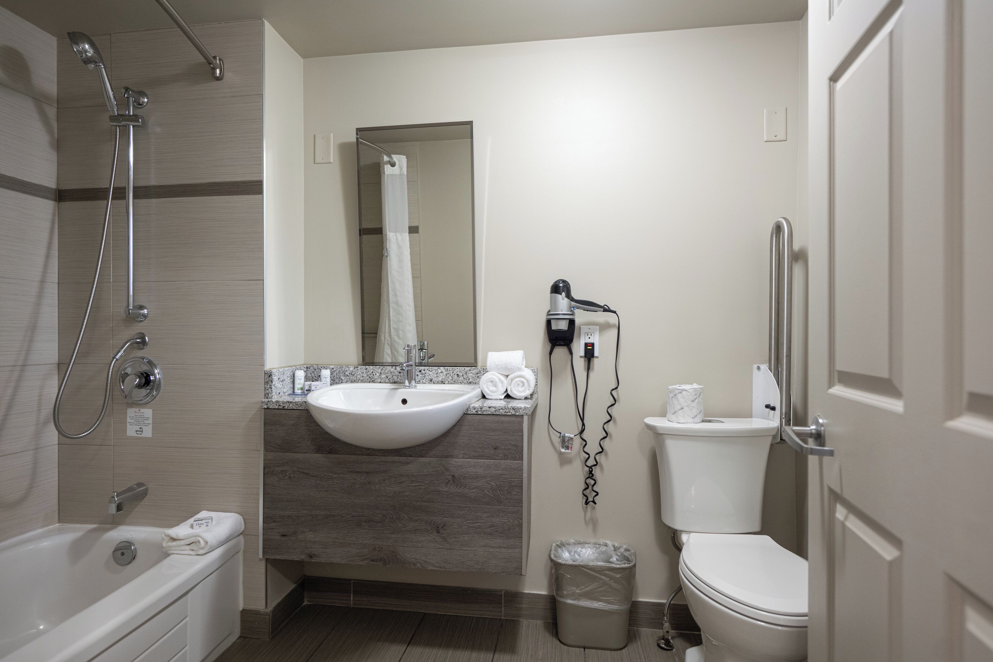 A modern bathroom with a bathtub, a sink, a toilet, and a shower.