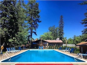 Una piscina al aire libre de temporada, sombrillas