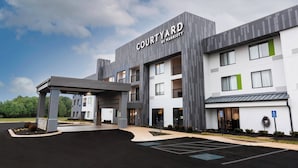 A Courtyard by Marriott hotel with a covered entrance, multiple floors, and a parking lot.
