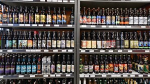 Variedad de botellas de cerveza en estanterías de un establecimiento.