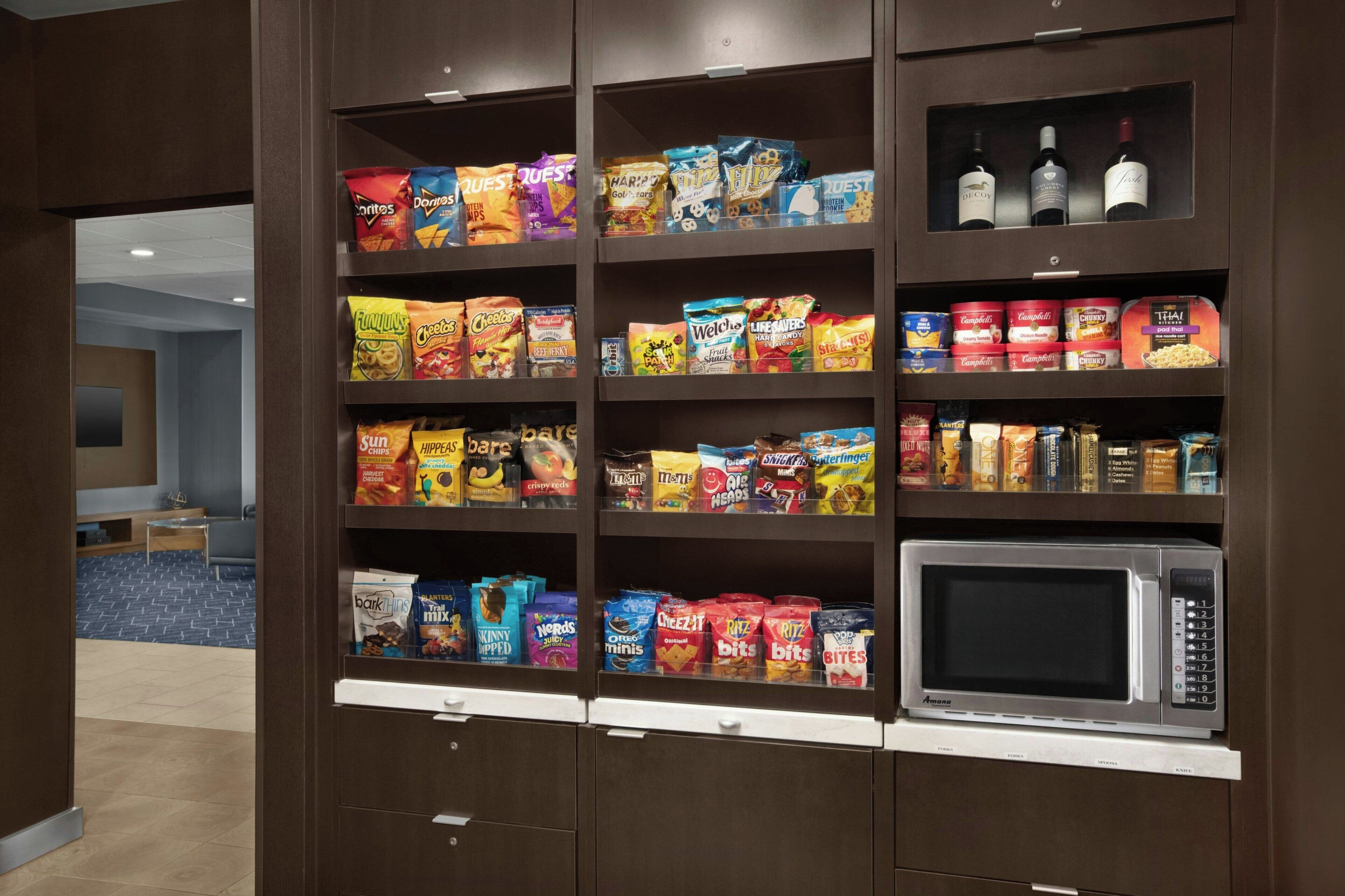 A snack display with various brands and a microwave.