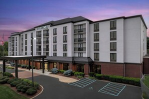 A multi-story hotel with a flat facade, a covered entrance, and a parking lot with marked handicapped spaces. - Courtyard by Marriott Bloomington (Bloomington)