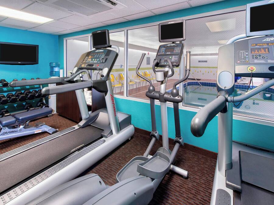 Un gimnasio con cintas de correr, elípticas y pesas.