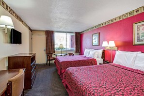 A hotel room with two beds, a desk, a chair, a TV, and a window with curtains. - Days Inn by Wyndham York Alabama (York)