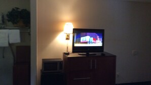 A television on a wooden cabinet with a lamp beside it. - Days Inn by Wyndham York Alabama (York)