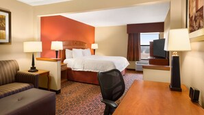 A hotel room with a bed, a desk, a chair, a TV, and two lamps. - Hampton Inn Wichita-East (Wichita)