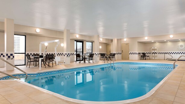 An indoor swimming pool with tiled flooring, a poolside seating area, and a ceiling with recessed lighting. - Hampton Inn Wichita-East (Wichita)