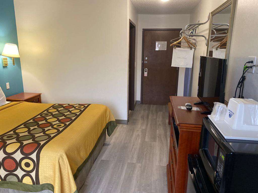 Une chambre d’hôtel équipée d’un lit, d’un bureau, d’un four à micro-ondes et d’un miroir.