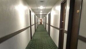 A long, narrow hallway with a patterned carpet and doors on both sides. - Americas Best Value Inn West Frankfort (West Frankfort)