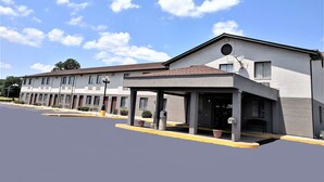 A two-story motel with a covered entrance and a parking lot. - Americas Best Value Inn West Frankfort (West Frankfort)