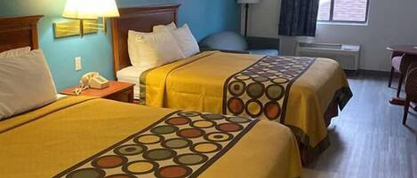 Una habitación de hotel con dos camas, un escritorio, una silla, una lámpara y una ventana con cortinas.