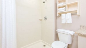A bathroom with a shower, toilet, and towel rack. - Super 8 by Wyndham Wichita South (Wichita)
