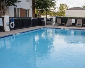 Una piscina al aire libre de temporada, sombrillas