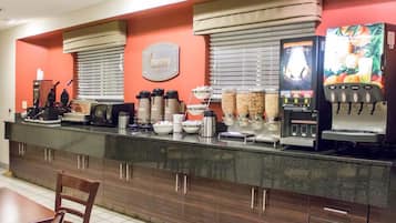 Ein Frühstücksbuffet mit Kaffeeautomaten, Saftspendern und einem Schild mit der Aufschrift 'morning buffet'.