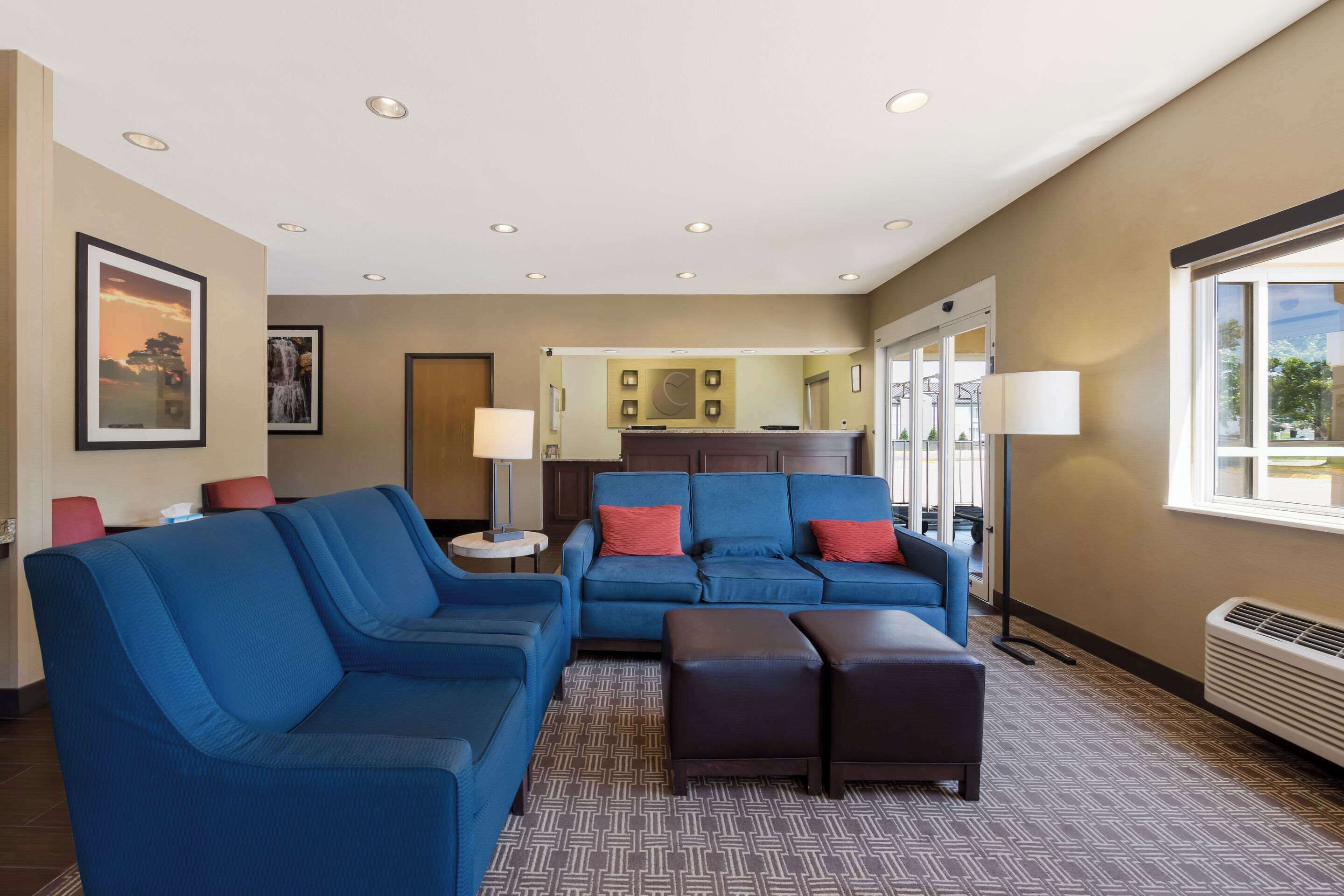 A hotel lobby with blue sofas, a coffee table, and a reception desk. - Comfort Inn Wichita East (Wichita)