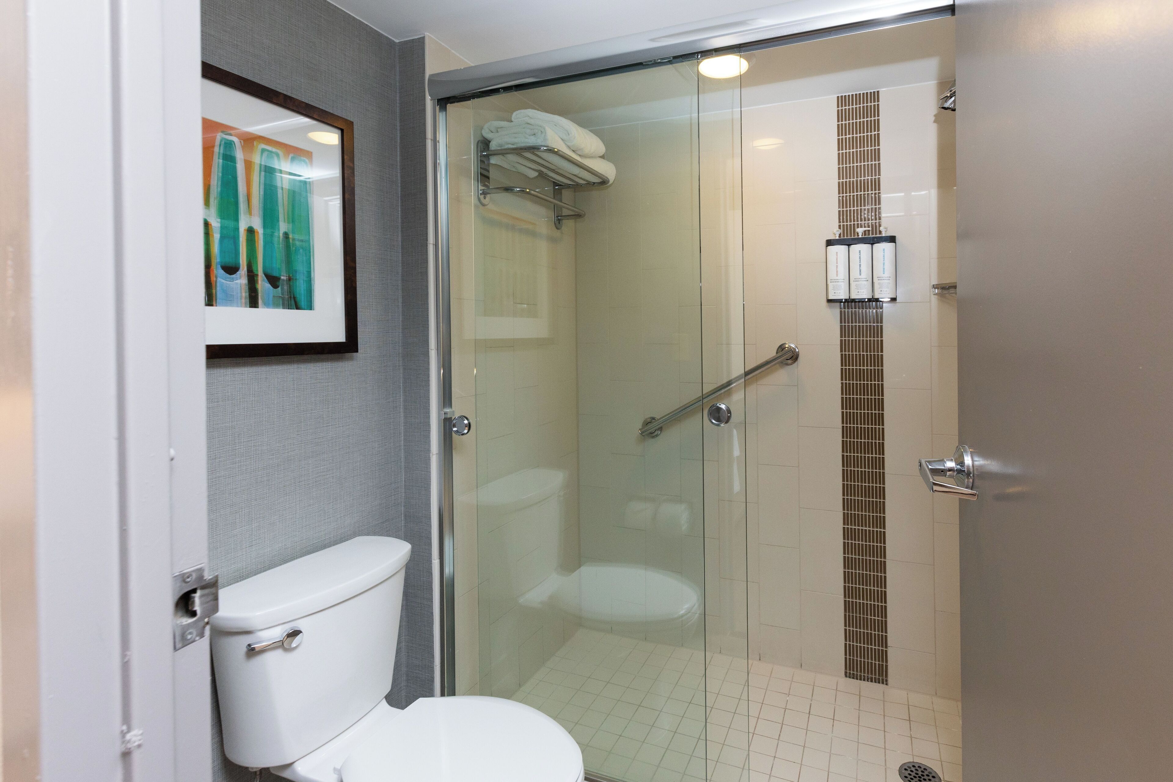 combined shower/bathtub, designer toiletries, hair dryer, towels