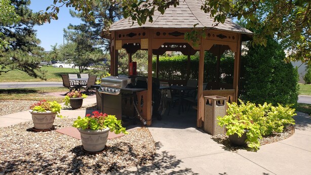 A gazebo with a grill, surrounded by potted plants and a paved patio. - MainStay Suites Wichita Northeast (Wichita)