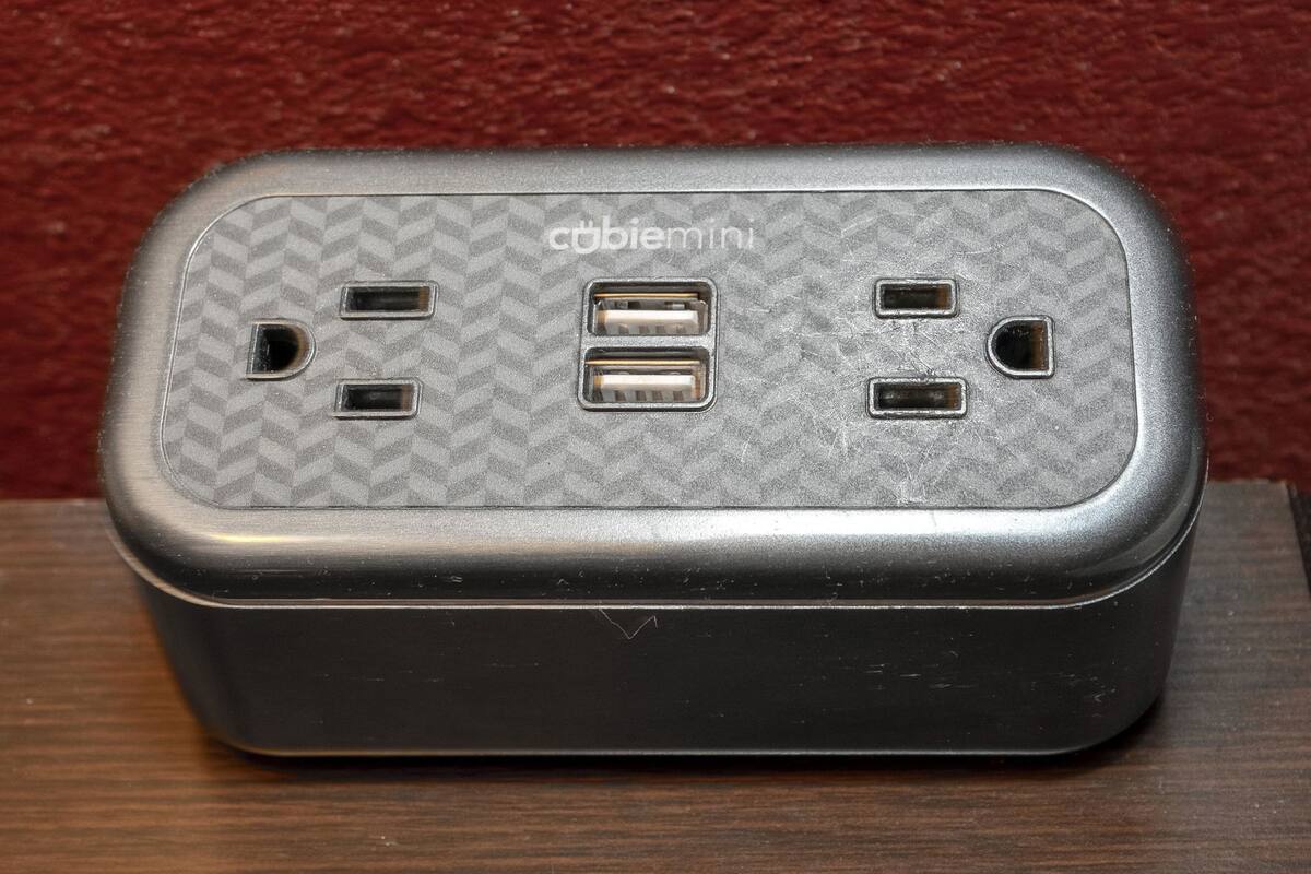 A portable device with a textured surface and the brand 'cobiemini' visible. It has two USB ports and two power outlets.