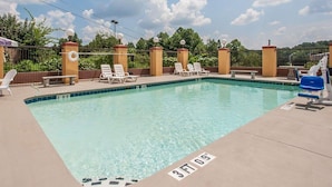 A rectangular swimming pool with clear blue water, surrounded by lounge chairs and a fence. - Econo Lodge Northport near University (Northport)