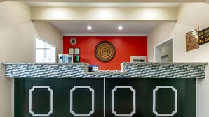 A reception desk with a mosaic tile top and a black panel with white geometric designs. - Econo Lodge Northport near University (Northport)