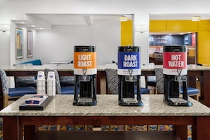 A coffee station with three coffee dispensers labeled 'Light Roast,' 'Dark Roast,' and 'Hot Water.' - Hampton Inn Lawrence (Lawrence)