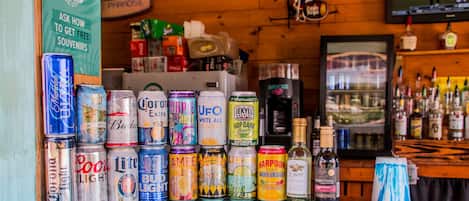 A bar counter with various beer cans and bottles, including Corona Light, Coors Light, Bud Light, and Harpoon.