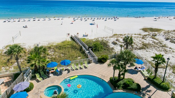 A beach resort with a swimming pool, lounge chairs, and umbrellas. - Holiday Inn Express Orange Beach by IHG (Orange Beach)