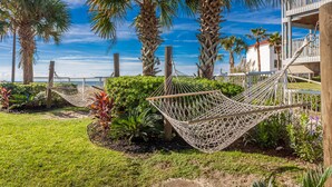 A hammock in a garden with palm trees and a view of the sea. - Holiday Inn Express Orange Beach by IHG (Orange Beach)