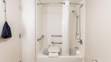 A standard hotel bathroom with a bathtub, shower, grab bars, and a towel rack.