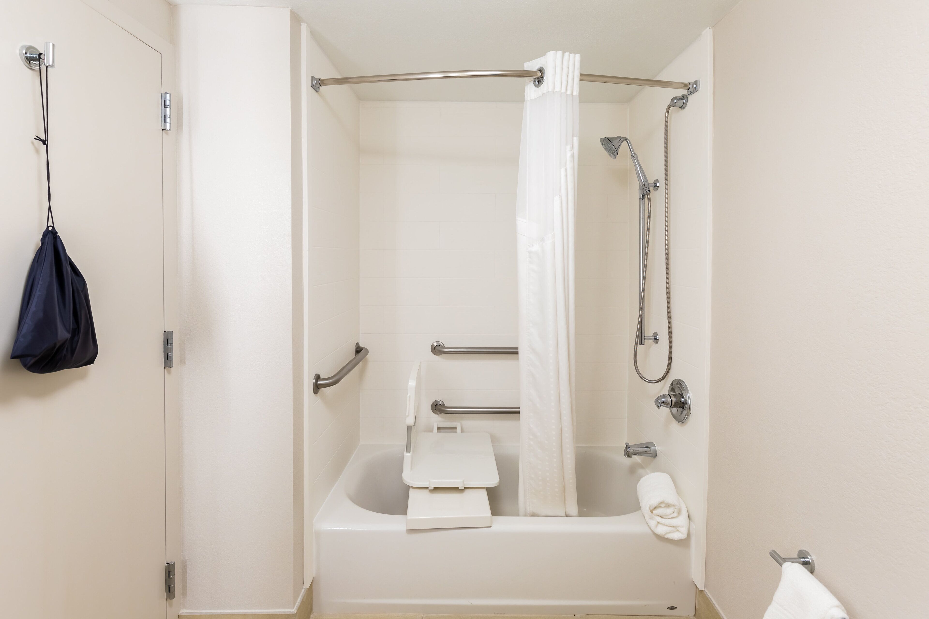 Een standaard hotelbadkamer met een bad, douche en toilet.