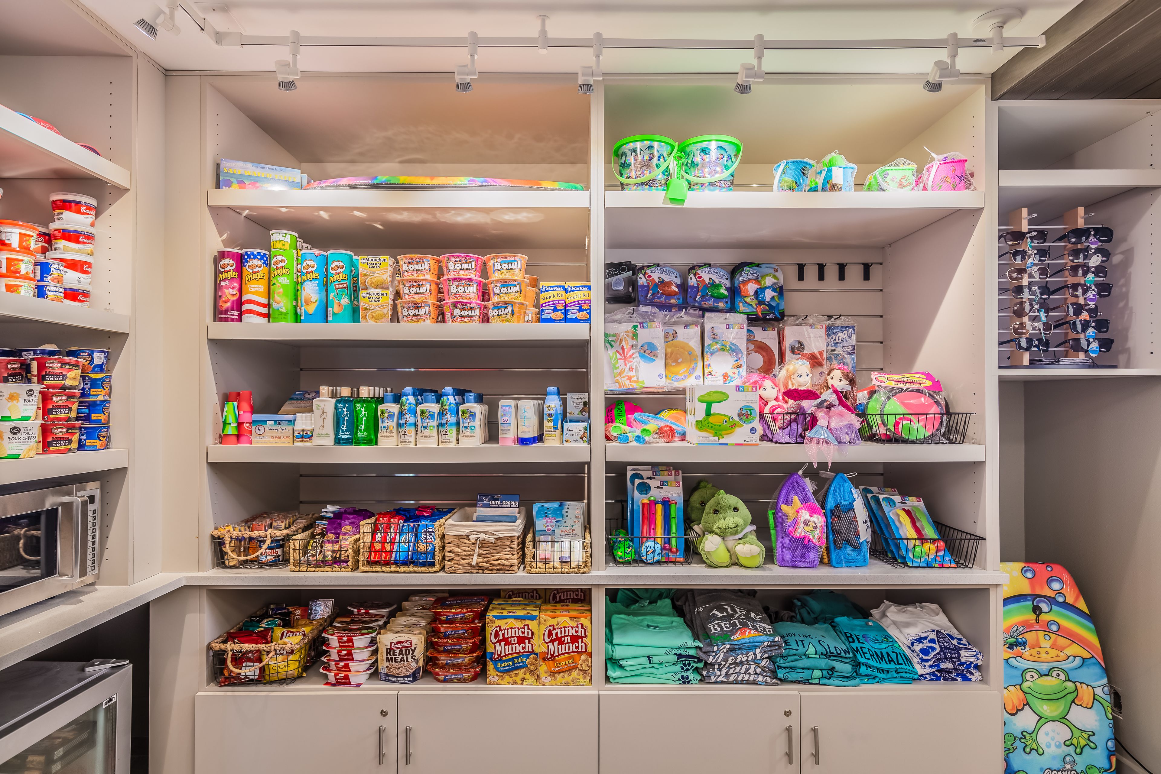 Un depósito trastero bien organizado con estantes que contienen diversos artículos como cajas de cereales, aperitivos y juguetes infantiles.