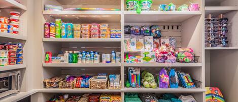 A well-organized storage unit with shelves containing various items such as cereal boxes, snacks, and children's toys.