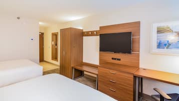 A hotel room with a bed, a desk, a television, and a wardrobe.