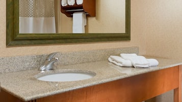 A bathroom with a sink, mirror, and towel rack.