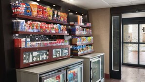A snack display with various brands and a refrigerated section with beverages. - Hampton Inn Chicago / Tinley Park (Tinley Park)