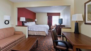 A hotel room with a bed, a sofa, a desk, a chair, a television, and lamps. - Hampton Inn Chicago / Tinley Park (Tinley Park)