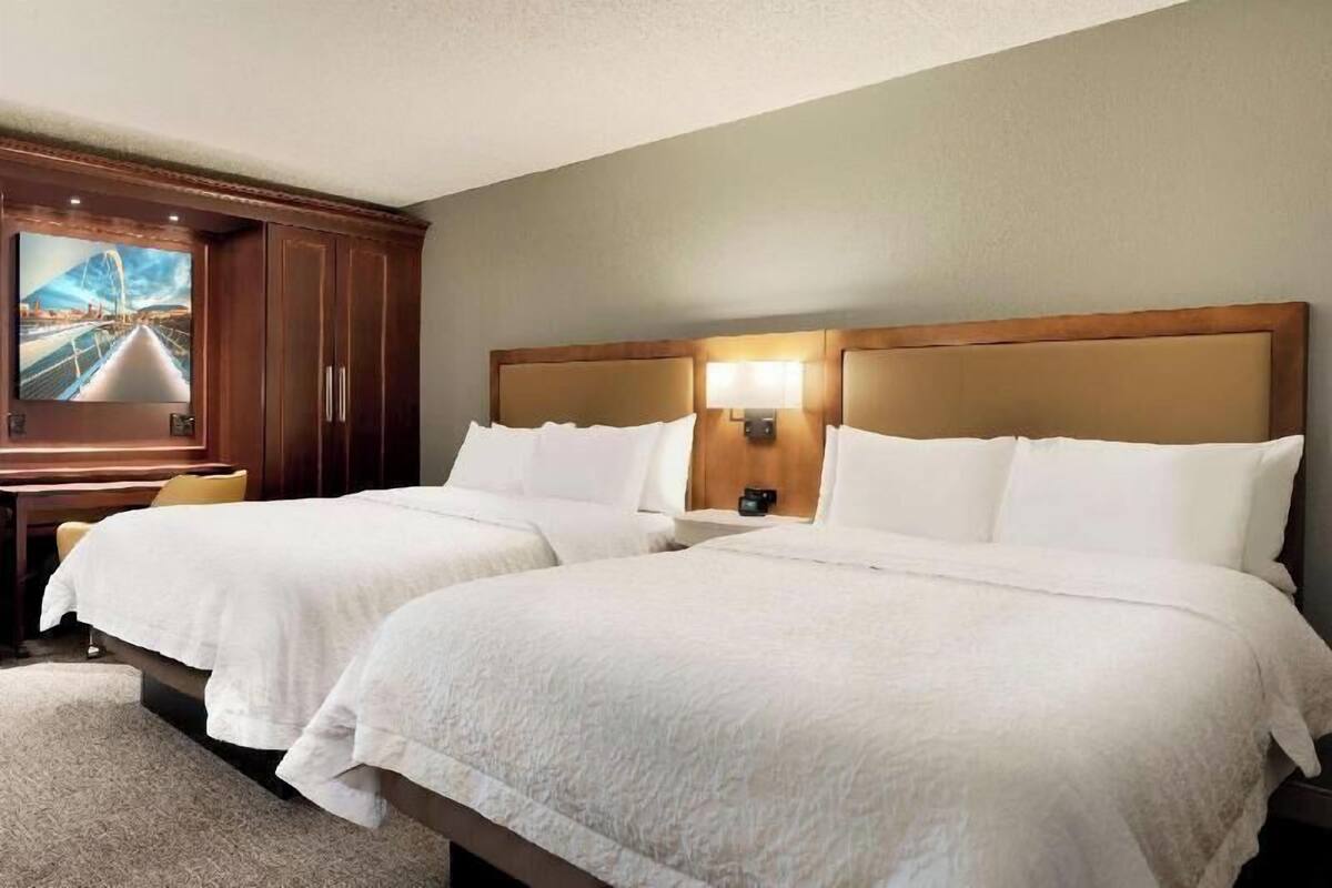 Une chambre d’hôtel avec deux lits, une télévision et un bureau.
