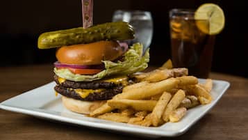 Un plato con una hamburguesa, papas fritas y una bebida.