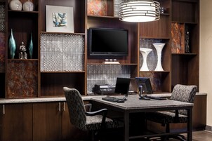 A modern dining area with a large flat-screen TV, a dining table, and chairs.
