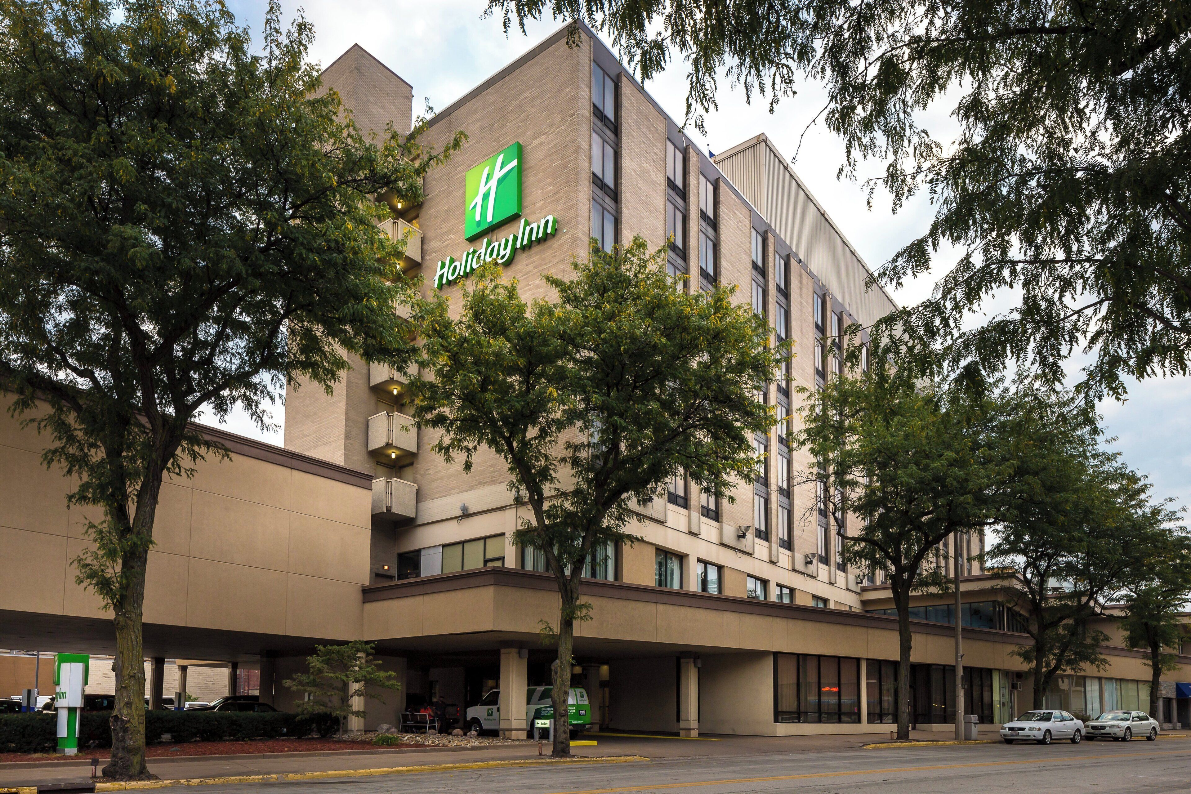 A Holiday Inn hotel with a brick facade, multiple floors, and a prominent green logo.