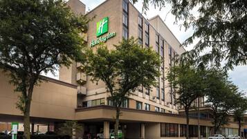 A Holiday Inn hotel with a brick facade, multiple floors, and a prominent green logo.