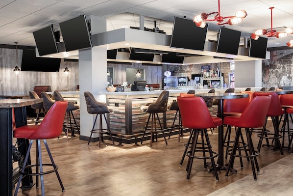 Un espace bar moderne avec des tabourets hauts et un comptoir.