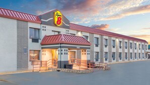 Een Super 8 hotel met een rood dak, een groot bord en een ruime parkeerplaats.
