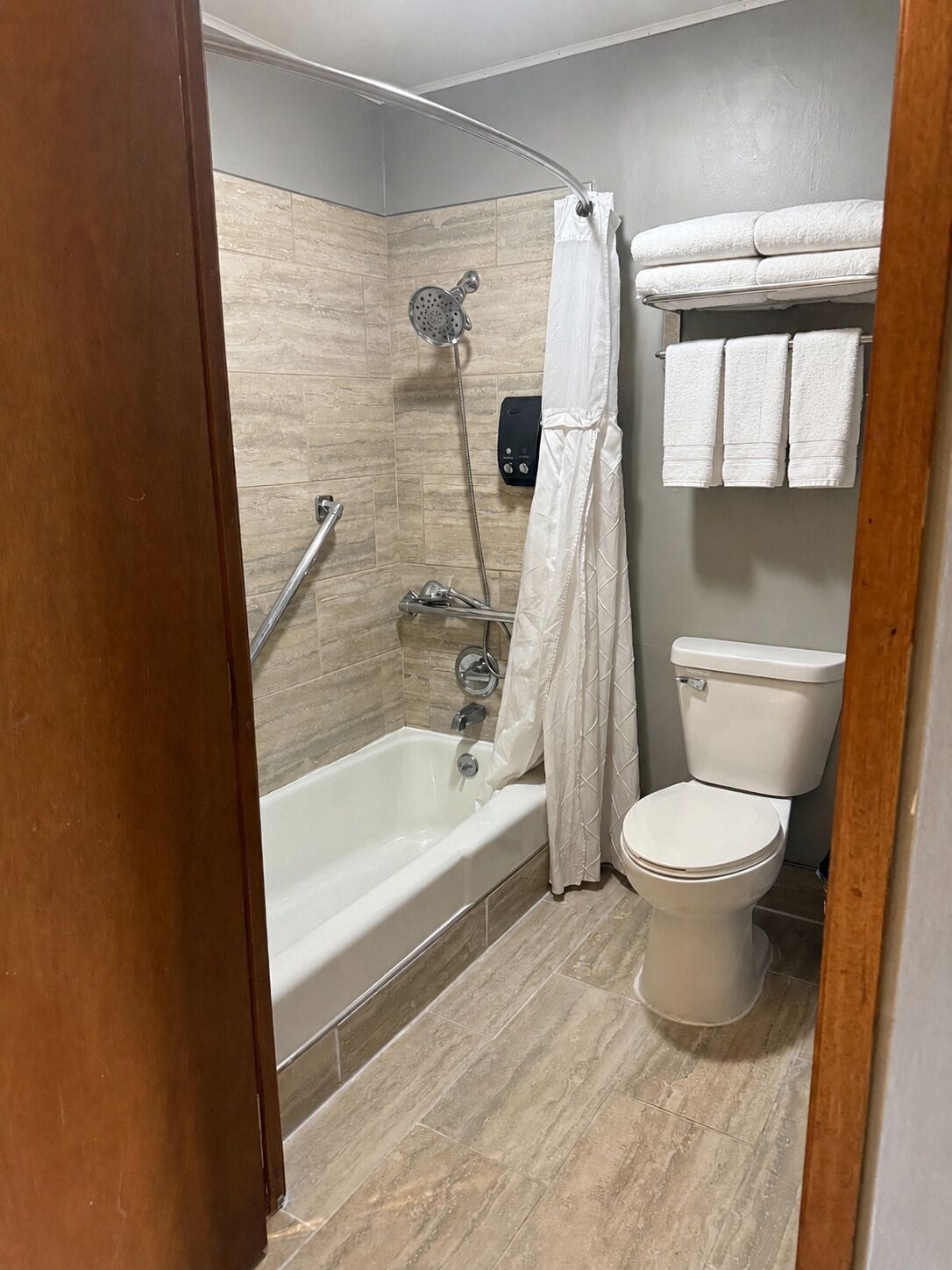 Une salle de bain équipée d’une baignoire, d’une douche, de toilettes et d’un porte-serviettes avec trois serviettes.