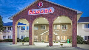 Un edifici de maó amb un rètol que diu "RAMADA" i un logotip a dalt.